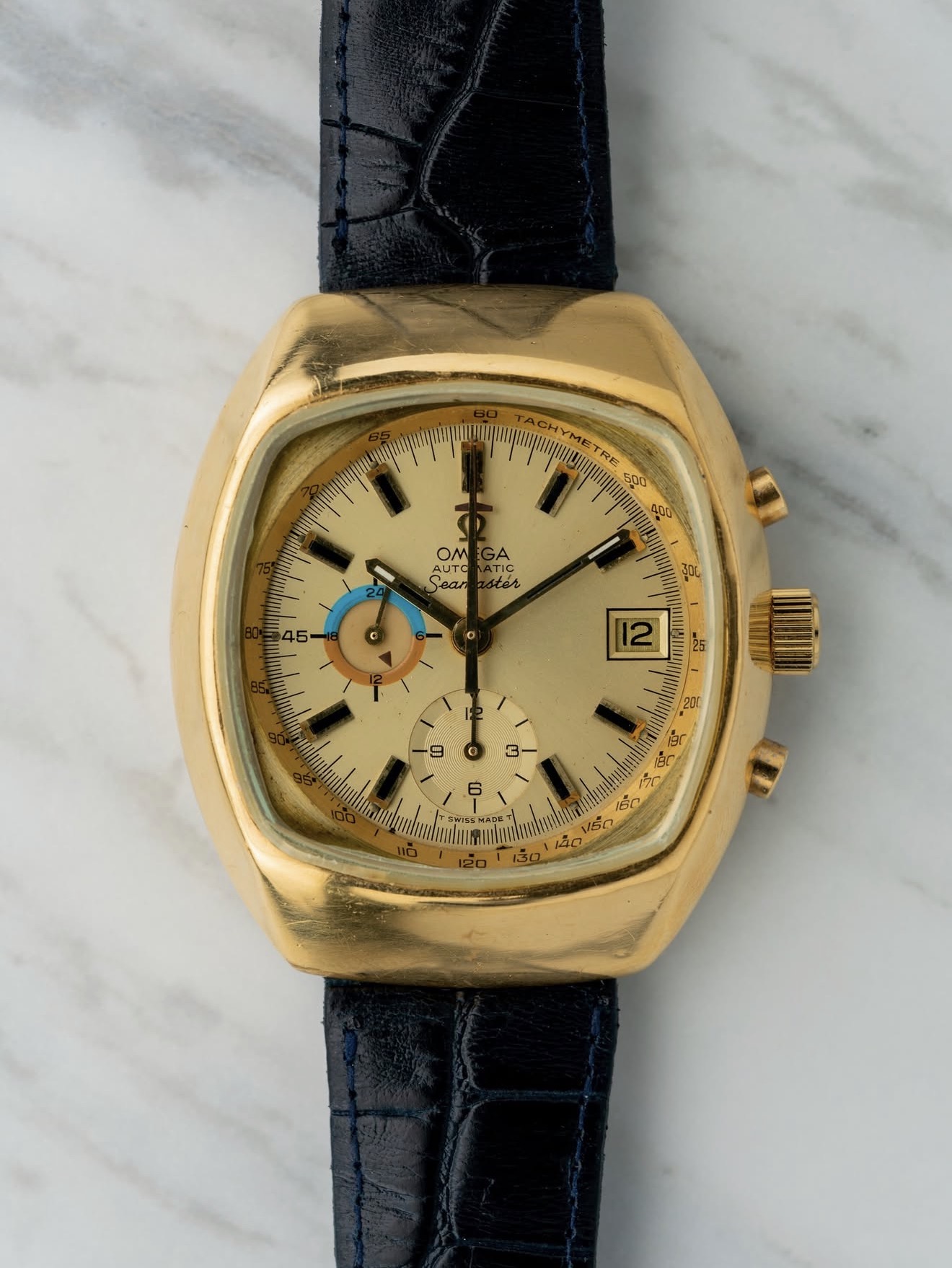 Vintage Omega Seamaster cushion-case chronograph in yellow gold on navy strap