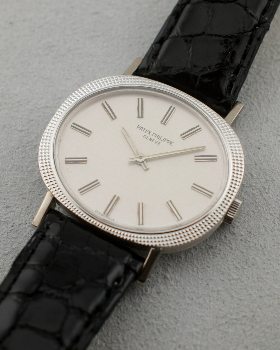 1960's Patek Philippe Calatrava with a white gold case and white dial. Hobnail pattern on its bezel and a black reptile strap.
