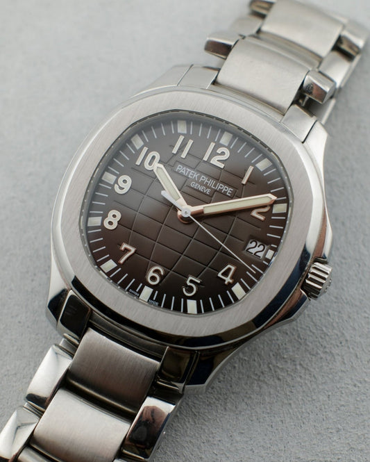 Stainless steel Patek Philippe Aquanaut reference 5167/1A.  It has a black dial and luminous hands and indices. Wearing a stainless steel factory Patek Philippe bracelet.