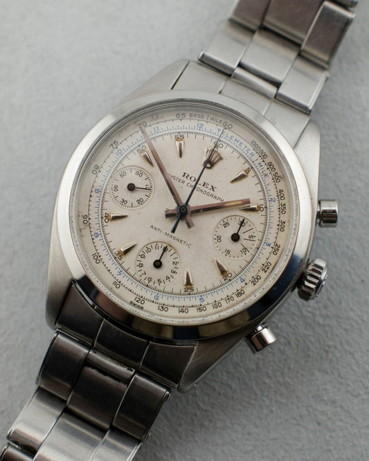 Steel colored Rolex Pre-Daytona reference 6234 with a white dial and blue tachymeter scale. It has a steel handset and all lume plots. It sits on a steel bracelet