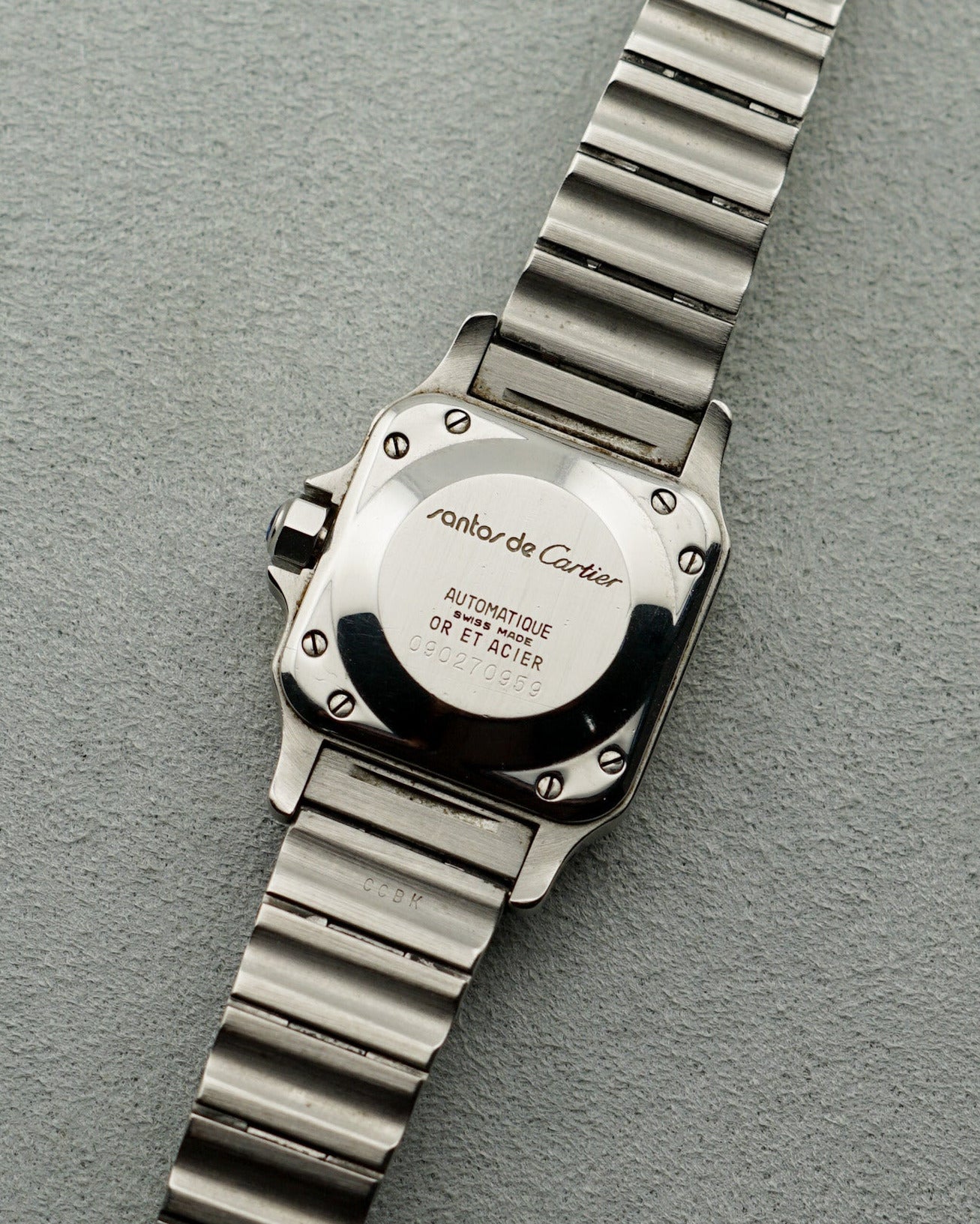 Cartier watch with metal band on a gray background