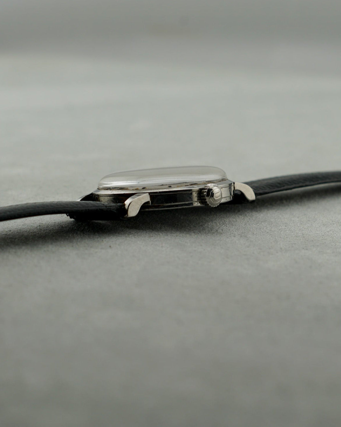 Close-up of a watch strap with a clasp on a gray background