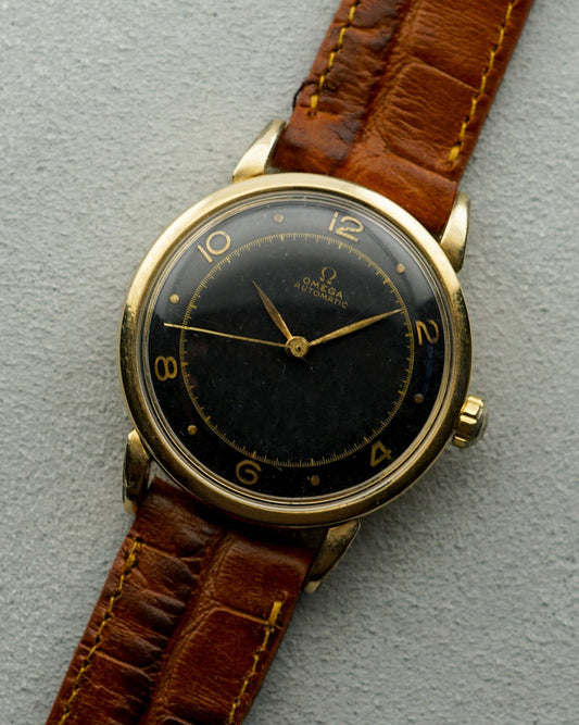 Vintage watch with brown leather strap on a gray background