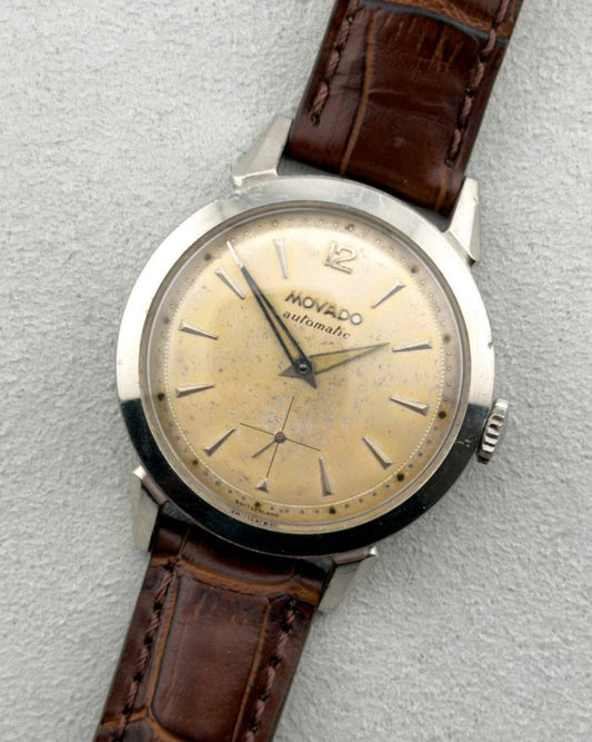 Vintage watch with brown leather strap on a light gray background